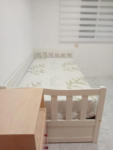 a white bed in a room with a drawer at Casa Denise in Playa de Gandia