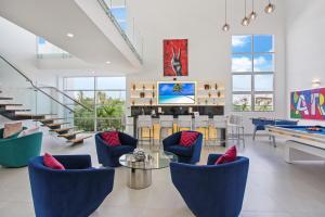 a living room with blue chairs and a pool table at Exquisite Contemporary 8BR Pool Villa with Chef, Butler, Maid, and Eden Roc Beach Club Access in Punta Cana