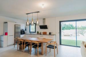 a kitchen and dining room with a wooden table and chairs at Maison en Provence avec piscine in Éguilles