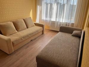 a living room with a couch and a window at saules street apartment in Ventspils