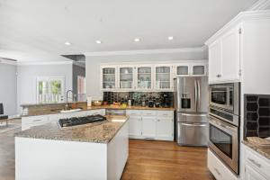 a kitchen with white cabinets and stainless steel appliances at Smyrna Home with Pool and Hot Tub! 20 Mi to Nashville! in Smyrna