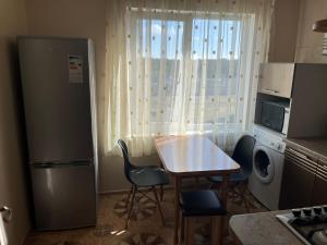 a kitchen with a refrigerator and a table and chairs at saules street apartment in Ventspils