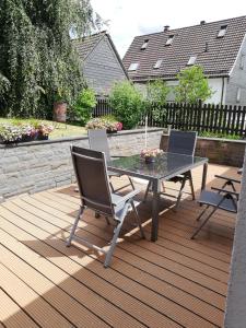 a patio with a table and chairs on a deck at Ferienwohnung Sauerland in Drolshagen