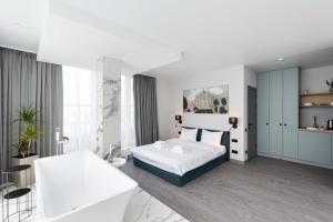 ein weißes Schlafzimmer mit einem Bett und einem Badezimmer in der Unterkunft Be The One Hotel in Kiew