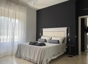 a bedroom with a bed with black walls and a white bedspread at Casa lu Monaco tranquillità a due passi dal mare in Porto dʼAscoli