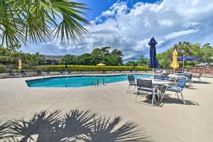 a pool with chairs and a table and umbrellas at Private Deck & Pool Access: Myrtle Beach Getaway! in Myrtle Beach