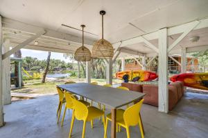 a dining room with a table and yellow chairs at Crystal River Retreat with Private Dock and Kayaks! in Crystal River