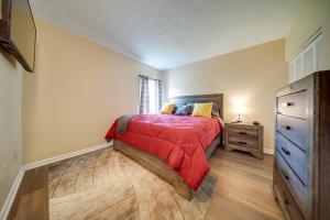 1 dormitorio con 1 cama con manta roja y vestidor en Vacation Rental with Porch and Views of Lake Erie!, en Ashtabula
