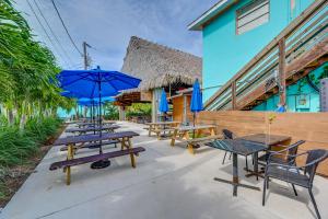 a row of tables and chairs with blue umbrellas at Everglades City Apt Near Marina and National Park! in Everglades City