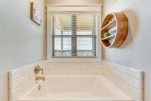 a white bathroom with a tub and a window at Russellville Home Near Hiking and Lake Access! in Russellville +21 photos