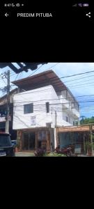 a white house with a car parked in front of it at Aluguel de suites e Apartamento in Itacaré