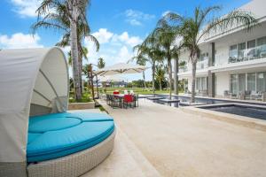 a patio with a table and chairs and a building at Exquisite Contemporary 8BR Pool Villa with Chef, Butler, Maid, and Eden Roc Beach Club Access in Punta Cana