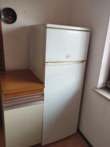 a white refrigerator in a corner of a kitchen at Apartments Dora in Medulin