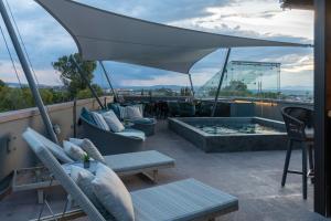 a patio with a hot tub and chairs and an umbrella at Hotel Apapacho Boutique in San Miguel de Allende
