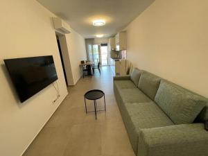 a living room with a couch and a flat screen tv at Markioli Residence in Sevid