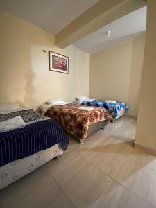 a bedroom with three beds in a room at Hostel Boulevard in Ica