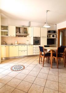 a kitchen with white cabinets and a table and chairs at Le Cave Apartment in Sirolo