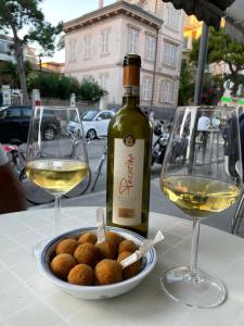 a bottle of wine and a bowl of food and two glasses at Casa lu Monaco tranquillità a due passi dal mare in Porto dʼAscoli