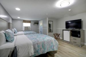 una camera con letto e TV a schermo piatto di Windrift Motel a West Yarmouth