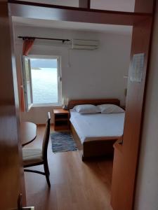 1 dormitorio con 1 cama, 1 silla y 1 ventana en Family Majčica - villa Malo Misto, en Klek