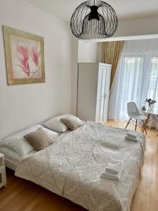 布拉格的住宿－Rezidence Kbely，一间卧室配有一张大床和一个吊灯。