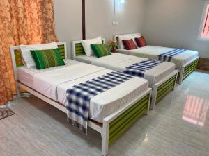três camas sentadas num quarto em บุญจินดา รีสอร์ท em Ban Phayom