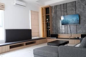 Il comprend un salon doté d'un canapé et d'une télévision à écran plat. dans l'établissement Villa 55 with Pool, Karaoke and Rooftop, à Bogor