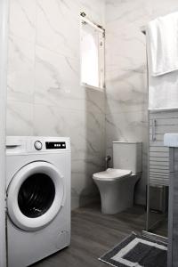 een wasmachine in een badkamer met een toilet bij Aqua Mare Luxury Apartments in Amfilochía