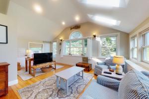 a living room with a couch and a tv at Garden Cottage By The Sea in Manchester