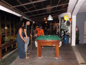 a man and a woman standing next to a pool table at Hostel Cristo Da Barra in Salvador