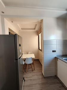 een keuken met een tafel en stoelen en een koelkast bij Very Nice Relaxing Apartment In Agadir El Houda in Agadir