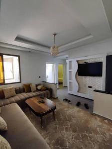 een woonkamer met een bank en een tv bij Very Nice Relaxing Apartment In Agadir El Houda in Agadir