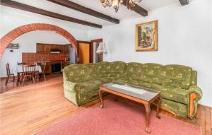 ein Wohnzimmer mit einem grünen Sofa und einem Tisch in der Unterkunft Lovely Apartment In Lopar With House A Panoramic View in Lopar