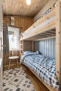 a bedroom with a bunk bed and a chair at Lyngebu. Nice family cabin with sea view. in Lyngdal