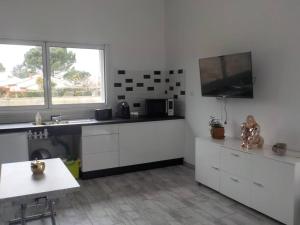 kuchnia z białymi szafkami i telewizorem z płaskim ekranem w obiekcie STUDIO LOSANJOS w mieście Brens