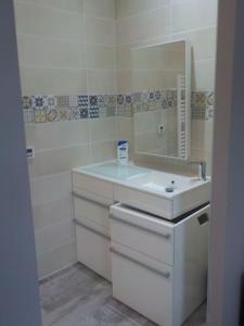 Baño blanco con lavabo y espejo en STUDIO LOSANJOS, en Brens