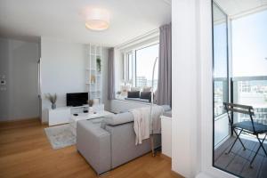een woonkamer met een bank en een tv bij Luxury 1BDRM on the 28th floor in Bratislava
