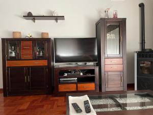 a living room with a flat screen tv and a entertainment center at Sweet Home in Moaña