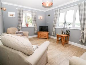 a living room with a couch and a tv at Farm View Lodge in Stroud