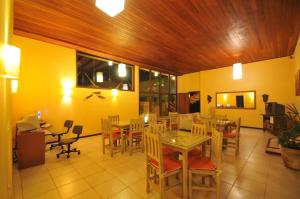 a dining room with tables and chairs and yellow walls at Pousada Amancay in Búzios