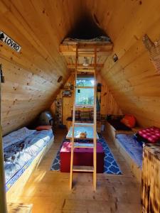 una habitación con 2 camas y una escalera en una cabaña en Get your zen among the trees, en Stahovica