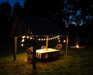 a table and chairs under a gazebo with lights at Frankówka in Łagów