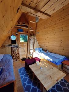 a room with a bed and a table in a cabin at Get your zen among the trees in Stahovica
