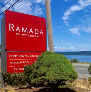 a red sign in front of a bush at Ramada by Wyndham Campbell River in Campbell River
