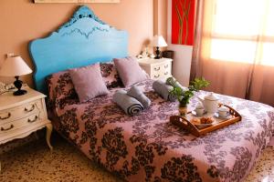 a bedroom with a bed with a blue head board at VACACIONES TIERRA Y MAR in El Campello