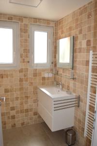 baño con lavabo blanco y 2 ventanas en Le Cavaou en Mérindol