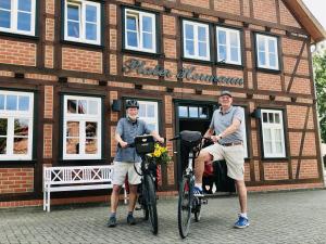 deux hommes debout avec leurs vélos devant un bâtiment dans l'établissement Plater Hermann, à Lüchow