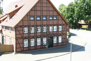 un edificio con techo de gambrel y ventanas blancas en Plater Hermann en Lüchow
