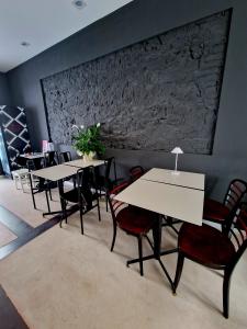 a dining room with tables and chairs and a stone wall at Mi Garba B&B in Viareggio