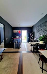 una sala da pranzo con pareti nere, tavoli e sedie di Mi Garba B&B a Viareggio